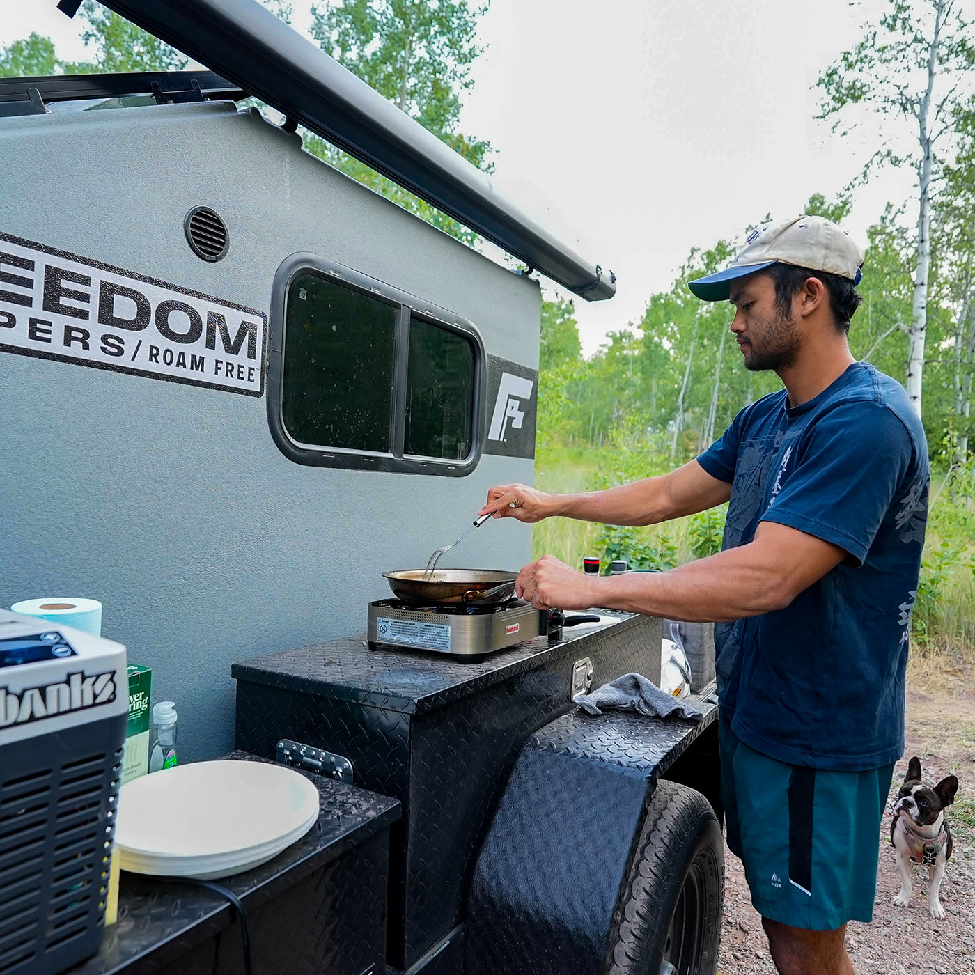 Cooking in a United States public park next to a Freedom Camper on a trailer